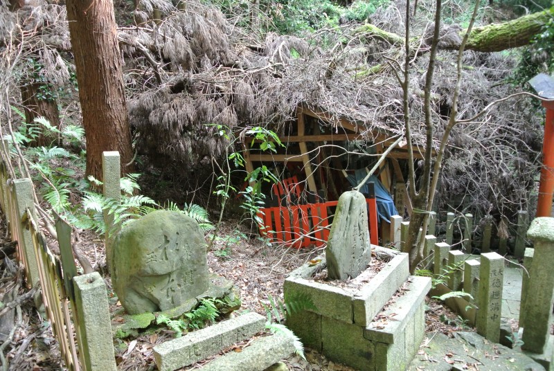Stone altars stand in front of the abandoned shrine