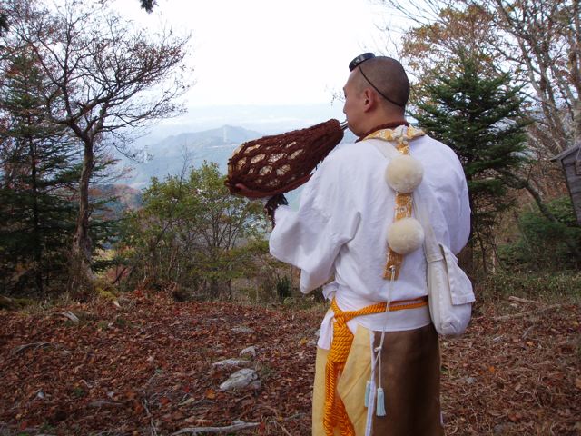 A mountain ascetic blows a horagai (conch horn) to announce his presence on the mountain
