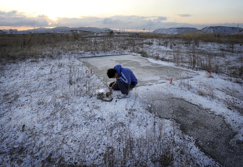 Man mourning his dead parents after the Tohoku disaster (photo Yomiuri Shimbun)