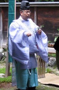 A priest about to present a tamagushi offering to a participant in a ceremony