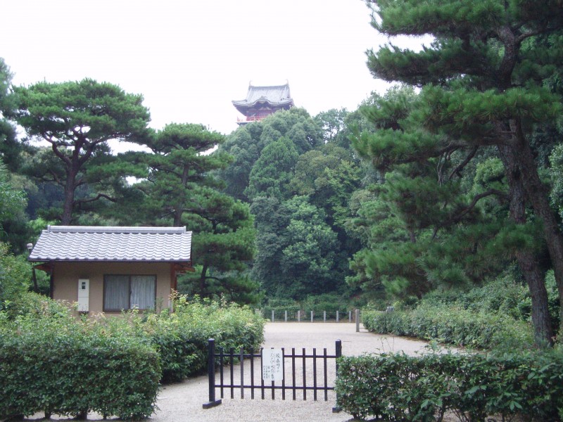 The modest entrance to the burial mound of Kyoto's founder, Emperor Kammu,.  In the background is Hideyoshi's Momoyama castle (rebuilt in modern times in concrete).