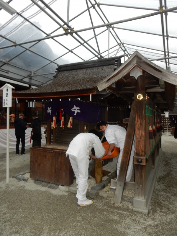 Priests empty out the takings from one of the popular Chinese zodiac subshrines in the Shimogamo inner compound.