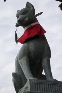 Kitsune, the fox guardian of Inari shrines, with a sheaf of rice