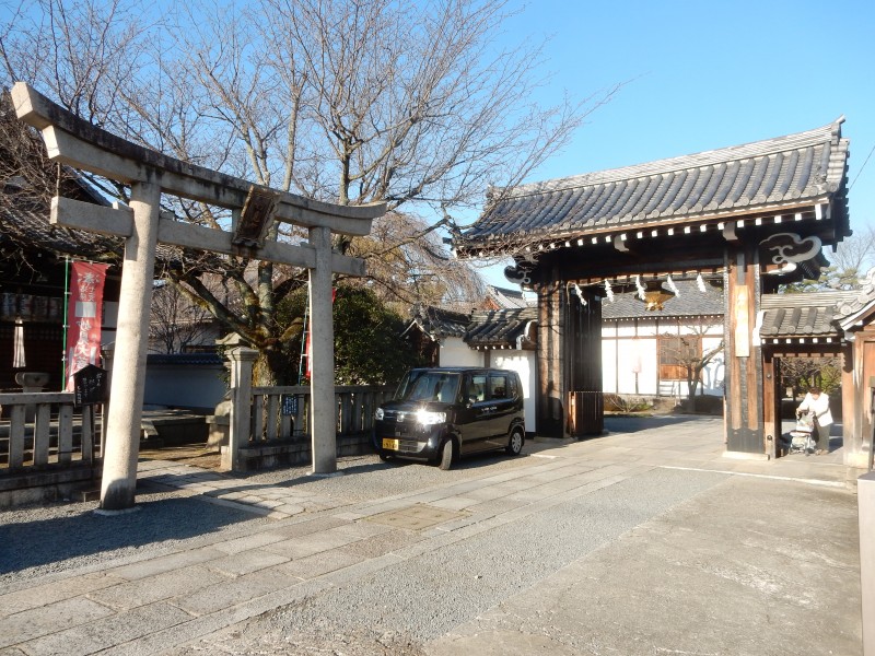 Nichiren temple with adjacent torii and Buddhist gate (and a visible means of transport between the two worlds!)