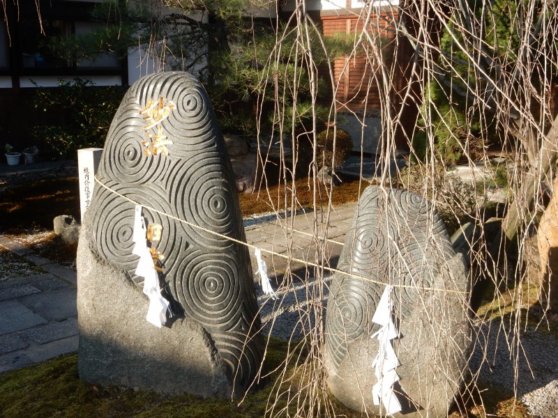 Sacred rocks have long been part of the Shinto tradition. These are Buddhist, as indicated by the whorls.